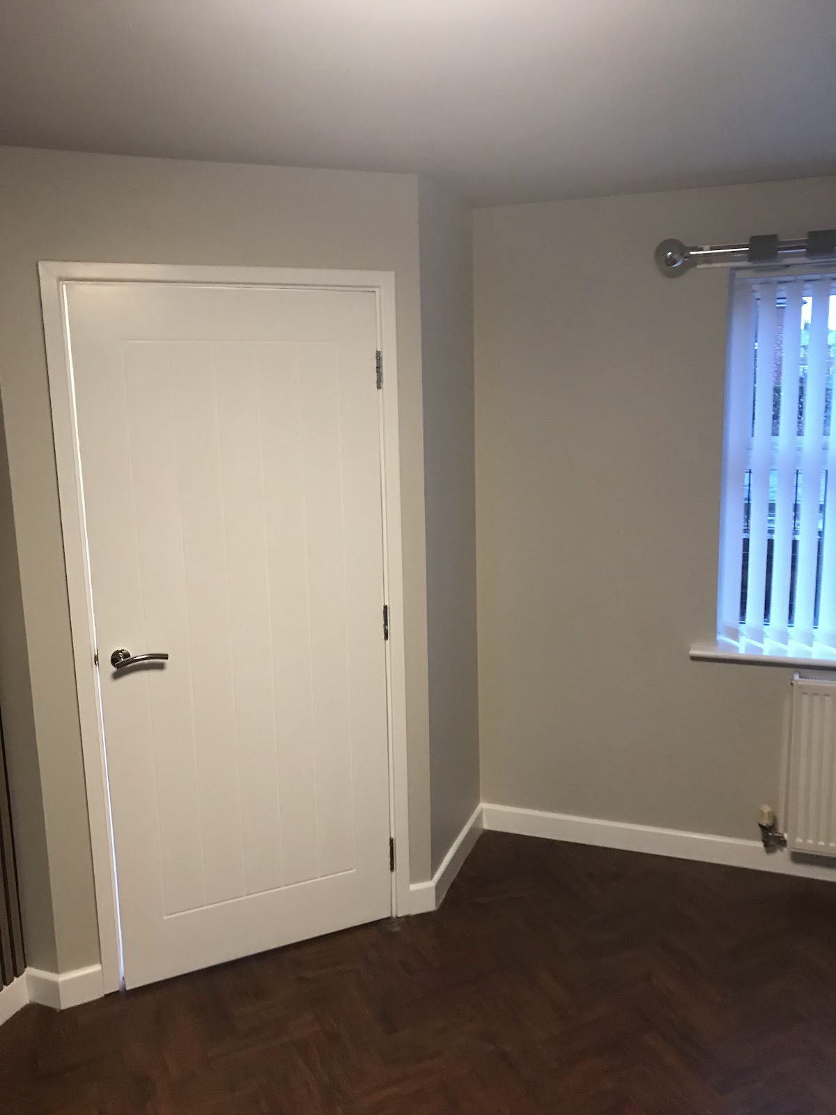 Bedroom finished in warm grey with white woodwork and parquet floor