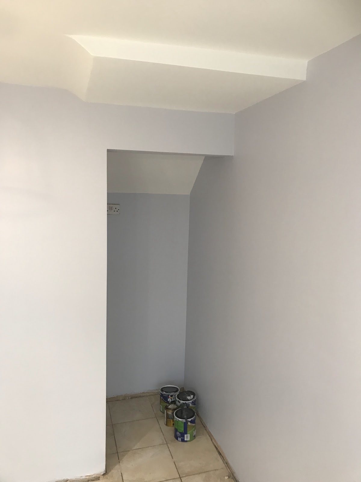 Alcove and understairs painted pale blue grey, paint tins on the floor mid job